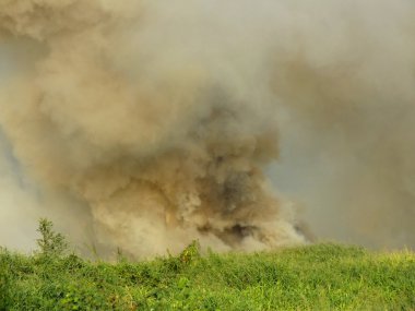 bir alan ve kalın bulutlar yanan yükselen gökyüzü duman duman ve ateş