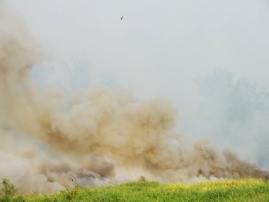 bir alan ve kalın bulutlar yanan yükselen gökyüzü duman duman ve ateş