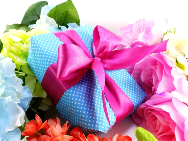 Geschenk-Box mit rosa Schleife und schönen bunten Blumen Hintergrund — Stockfoto