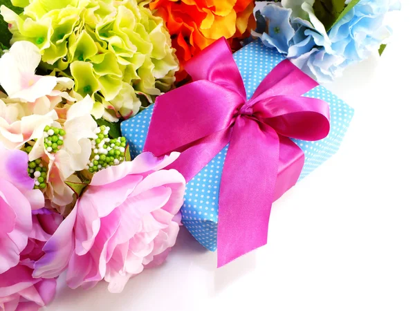 gift box present with pink ribbon bow and beautiful colorful flowers background