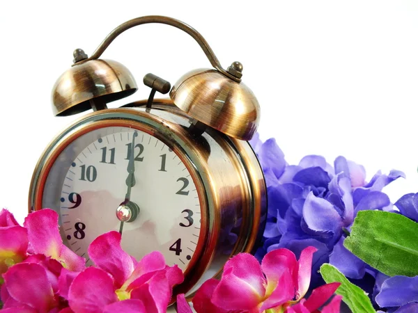 Frühlingszeit mit Wecker und künstlichen Blumen Blumenstrauß Hintergrund — Stockfoto