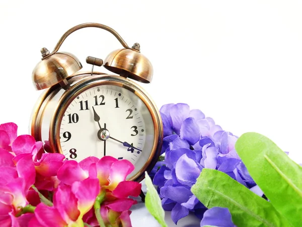 Frühlingszeit mit Wecker und künstlichen Blumen Blumenstrauß Hintergrund — Stockfoto