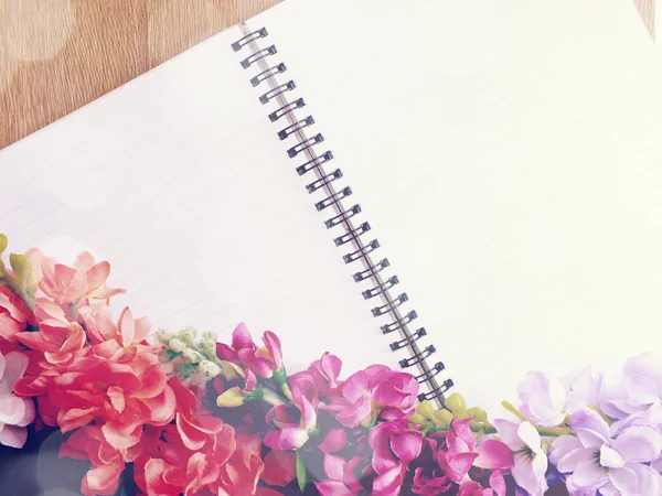 Deník prázdný poznámkového bloku s růžovou květinou na dřevěné pozadí — Stock fotografie