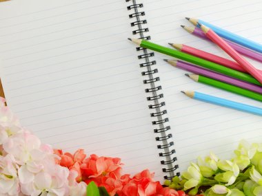 defter kalem ve beyaz bir arka plan üzerinde çiçekler