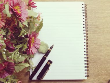 ahşap arka plan üzerinde pembe çiçekli boş defter günlüğü