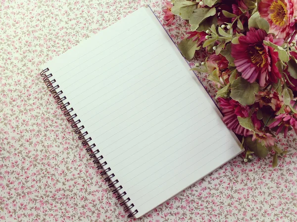 Prázdné notebook s květem na dřevěný stůl — Stock fotografie