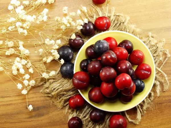 Rote Pflaume auf Holzhintergrund Draufsicht — Stockfoto