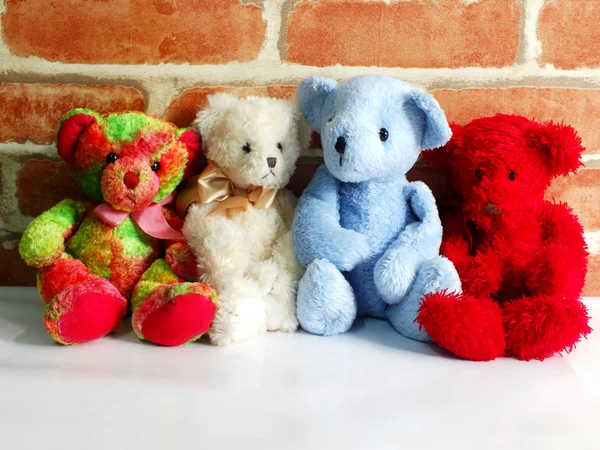 Un groupe d'ours en peluche mignon assis ensemble contre avec du papier peint — Photo