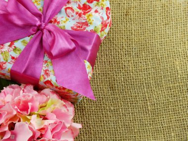 hediye kutusu pembe kurdele yay ve güzel renkli çiçekler arka plan ile mevcut