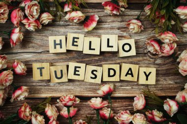 Merhaba Salı alfabe alfabesi. Ahşap arka planda çiçek açan mektup.