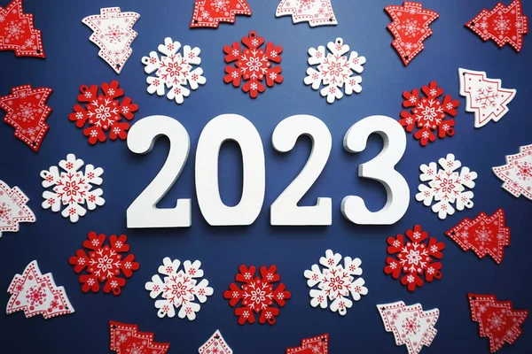 Mutlu yıllar 2023 alfabe mektupları ve mavi arka planda Noel süslemeleri.