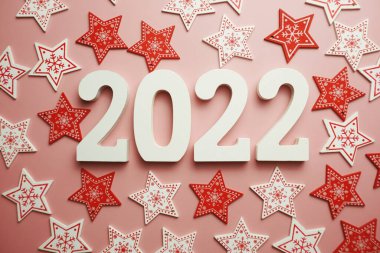 Yeni yılınız kutlu olsun. Pembe arka planda Noel süslemesi olan 2022 alfabesi.