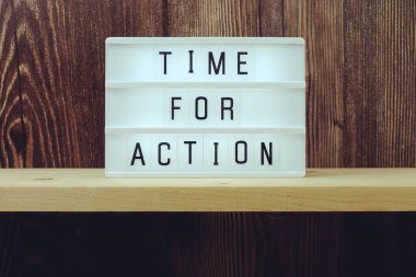 Ahşap zemin üzerinde ışık kutusunda Eylem kelimesi zamanı