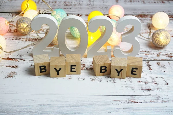 Elveda 2023 alfabe harfleri ve ahşap arka planda uzay kopyası.