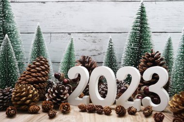 Yeni yılın kutlu olsun takvim 2023 Noel ağacı ve çam kozalakları ile beyaz ahşap arka planda konsept dekorasyonu