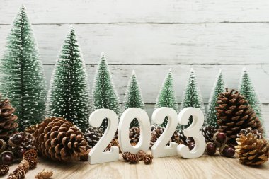 Yeni yılın kutlu olsun takvim 2023 Noel ağacı ve çam kozalakları ile beyaz ahşap arka planda konsept dekorasyonu