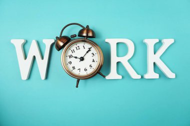 Mavi arkaplanda alarm saati olan alfabe harflerini çalıştır