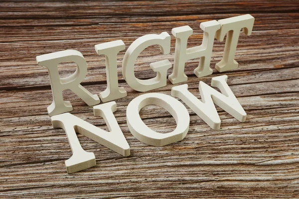 Right Now Word alphabet letters on wooden background