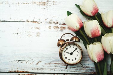 Klasik Alarm Saati ve ahşap arka planda uzay kopyası olan Lale Buketi