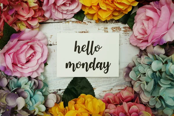 Hello Monday Card with colorful flowers border frame on wooden background