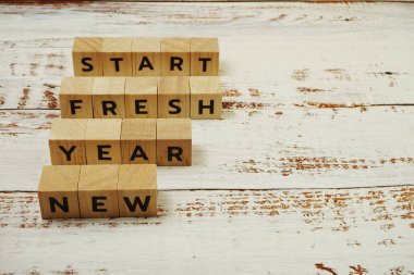 Ahşap zemin üzerinde Yeni Yıl Taze Başlangıç Kelimesi alfabesi harfleri