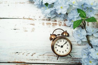 Klasik Alarm Saati ve Çiçek Buketi ahşap arka planda yer kopyası