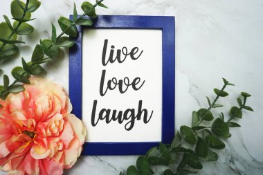 Canlı Aşk Gülüşü mavi çerçevede yeşil izinli ve pembe çiçekli mermer arka planda yatıyordu.