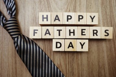 Mutlu Babalar Günü alfabesi harfleri ve tahta arka planda kravat.