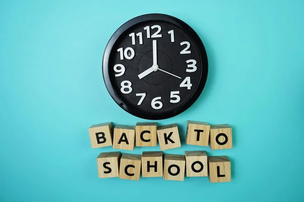 Back to School with clock on blue background