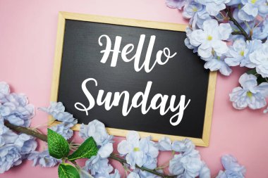 Merhaba Pazar metni ahşap karatahta ve çiçek süslemesi pembe arka planda