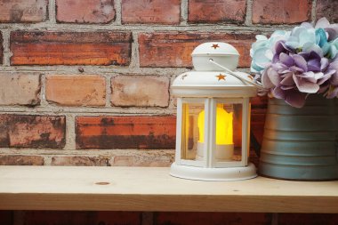 Ahşap rafta LED mum ışığı olan beyaz fener ev dekorasyonu