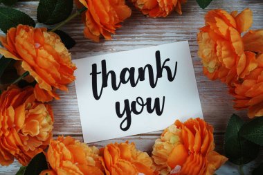 Tahta arka planda çiçek desenli teşekkür kartı.