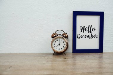 Merhaba Aralık daktilo metni alarm saati ahşap masa ve beyaz duvar arkaplanı