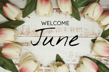 Hoş geldiniz Haziran metni ve lale çiçeği süslemesi ahşap arka planda