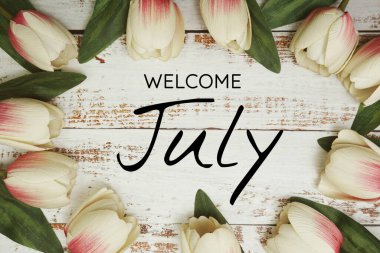 Hoş geldiniz Temmuz metni ve lale çiçeği süslemesi ahşap arka planda