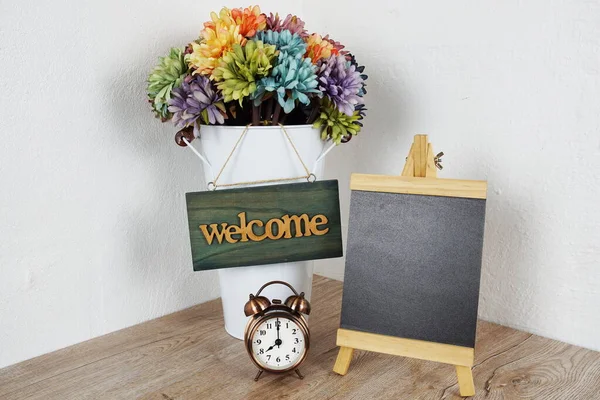Wooden easel with welcome board and daisy flower bouquet