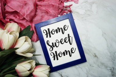 Home Sweet Home hattatlık ve pembe çiçek düz mermer zemin üzerinde yatıyordu