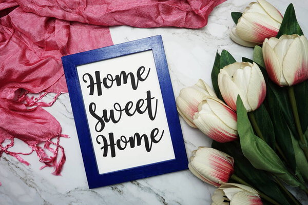 Home Sweet Home calligraphy and tulip flower flat lay on marble background