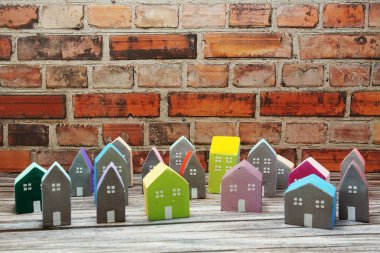 Ahşap arka planda düzenlenmiş renkli minyatür ev