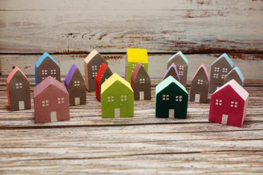 Ahşap arka planda düzenlenmiş renkli minyatür ev