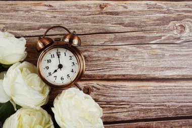 Beyaz şakayık çiçekli çalar saat. Ahşap zemin üzerinde kenar çerçeve.