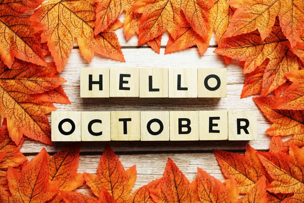 Happy October alphabet letter with maple leaves decoration on wooden background