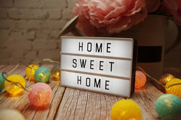 Home Sweet Home metni ahşap arka planda ışık kutusu üzerine