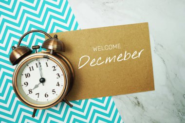 Kağıt üzerinde aralık ayında mermer zemin üzerinde alarm saati olan tipografi metnine hoşgeldiniz