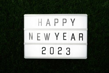 2023 Mutlu yıllar. Yeşil çimlerin üzerinde düz bir kutuda mutlu yıllar dilerim.
