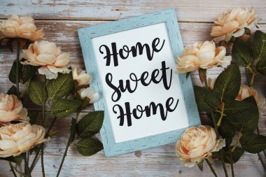 Home Sweet Home typography text with flower decoation on wooden background clipart