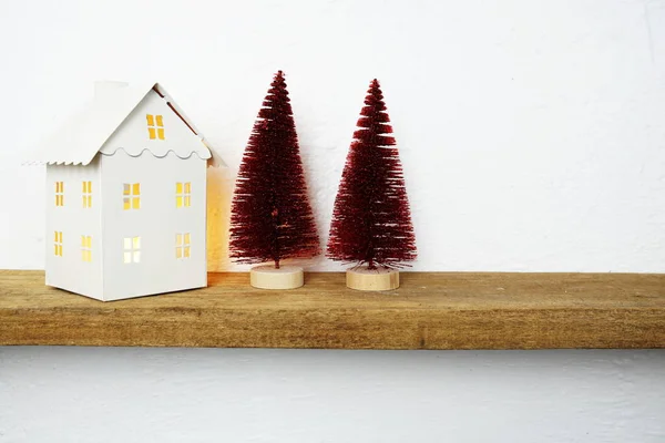 クリスマスツリーと白の家の燭台で飾られた木製の棚 — ストック写真