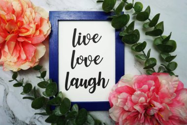 Canlı Aşk Gülüşü mavi çerçevede yeşil izinli ve pembe çiçekli mermer arka planda yatıyordu.