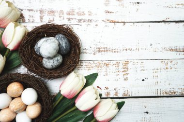 Paskalya yumurtaları ve çiçek buketli Paskalya arkaplanı. Kopyalama alanı olan üst görünüm