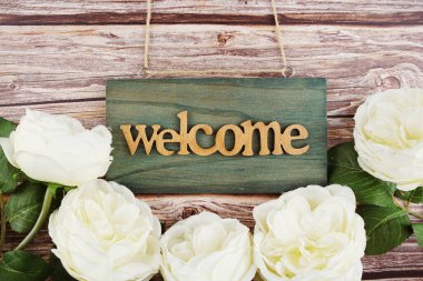 Hoş geldiniz. Ahşap zemin üzerinde çiçek açan saat.